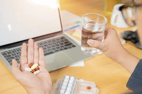 Back view and selective focus of Business man holding many pill medicine an.. Foto stock