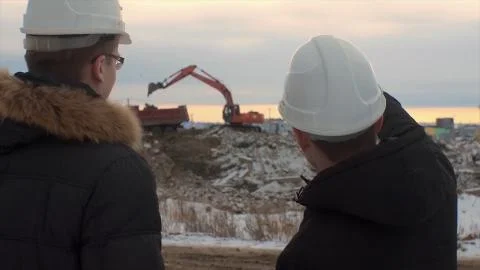 Back view of architects inspecting construction site. Two engineers in hard hats Foto stock
