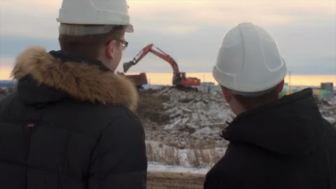 Back view of architects inspecting construction site. Two engineers in hard hats Foto stock