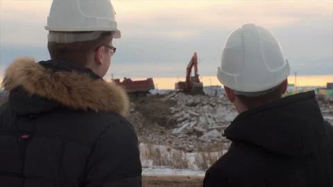 Back view of architects inspecting construction site. Two engineers in hard hats Foto stock