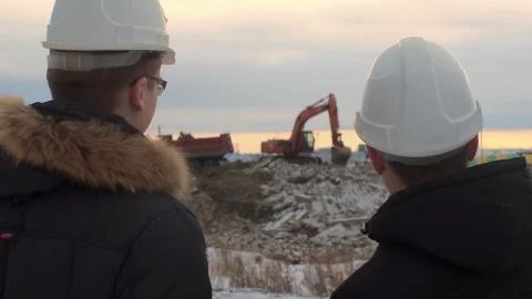 Back view of architects inspecting construction site. Two engineers in hard hats Foto stock