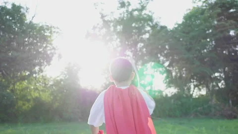 Back view of Asian boy holding sword in his hand and running in the park 스톡 동영상 173353413