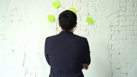 Back view of asian businessman pulling the colorful sticky paper note on whit Stock Footage 167049813