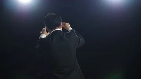 Back View Of Asian Conductor Man Holding A Baton And Showing Gesture Stock Footage 196958393