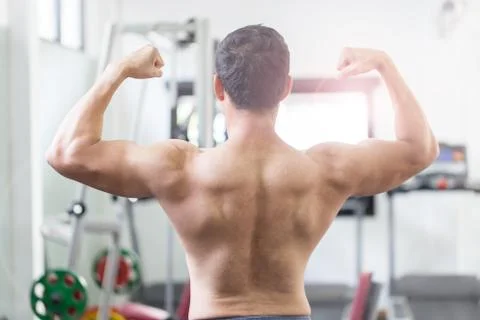 Back of view Asian men doing bodybuilder Rear Double Biceps pose in gym so st Stock Photos