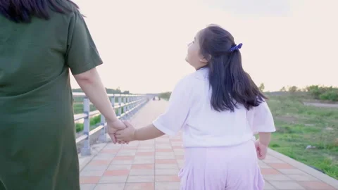 Back view of Asian mom and kid holding hand and running outdoor Video stock 167948714