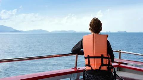 Back view of Asian woman in life vest relaxing on balcony enjoying view from  Stock Photos