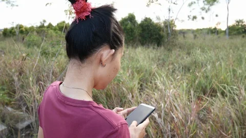 Back view of an Asian woman using a smartphone in the park Stock Footage 127998575