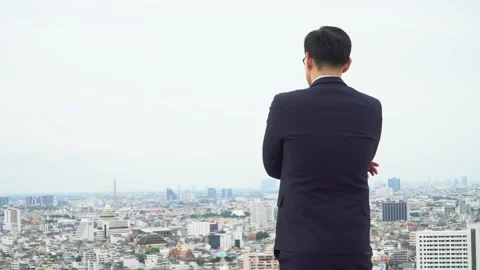 Back view of asian young business  man in suit standing on roof top looking a Stock Footage 143149946