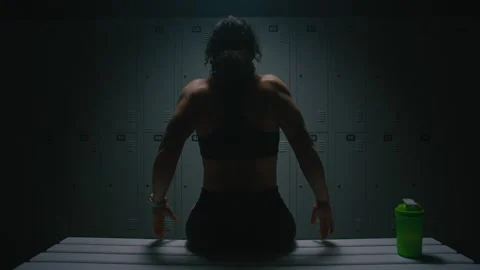 Back View of Athletic Woman Stretching Muscles After Workout in Locker Room Stock Footage 335397657