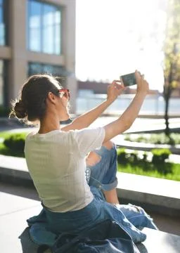 Back view of attractive woman using mobile phone on the street Stock Photos