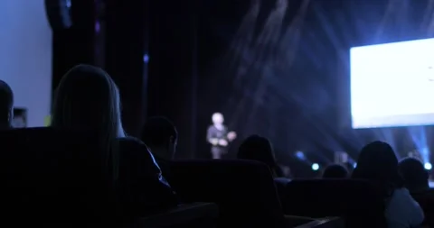 Back view of the audience sitting at a business conference. Speaker is holding a Stock Footage 168048631