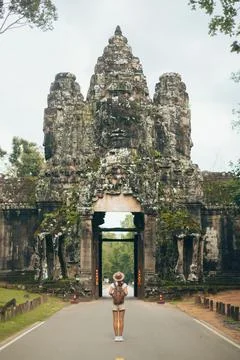 Back View Of Backpacker At Angkor Thom Gate, Bayon Faces, Cambodia Stock Photos