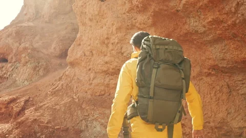 Back view at backpacker walking way forward through rocky mountain Stock Footage 287867224