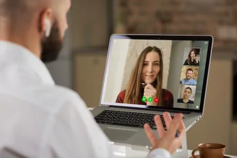 A back view of a bald guy with a beard who is working remotely on laptop at h Stock Photos
