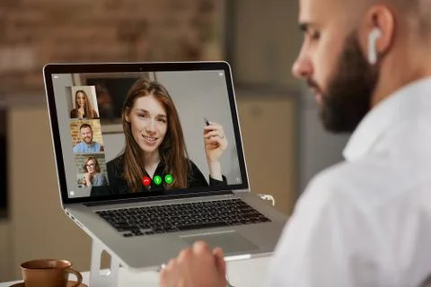 Back view of a bald man who is listening to a colleague on a video conference Stock Photos