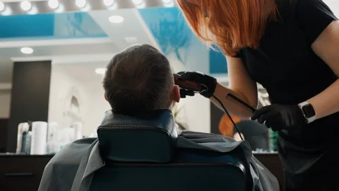 Back view of barber trimming beard of client Stock Footage 126601893