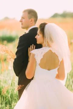 The back view of the bare shoulders of the bride leaning on the groom in the Stock Photos