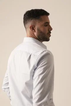 Back view of bearded young man posing on white background. Vertical mock-up. Photos