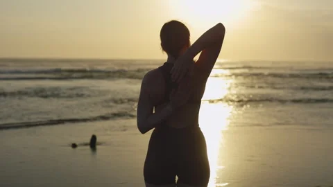 Back View of the Beautiful Blonde Woman Stretches Her Arms on the Seashore Stock Footage 276690553