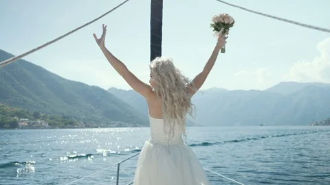 Back view of Beautiful bride stands on the yacht on sunny day sailboat Video stock 92387287