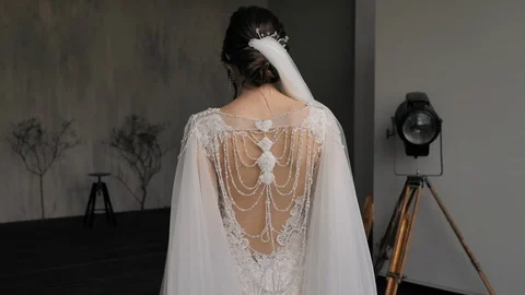  Back view of beautiful bride in wedding dress decorated with beads and veil. Stock Footage 128600166