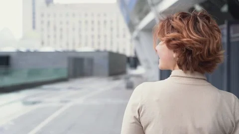 Back view of beautiful red haired woman walking on the street, looking away Stock-Footage 154755939