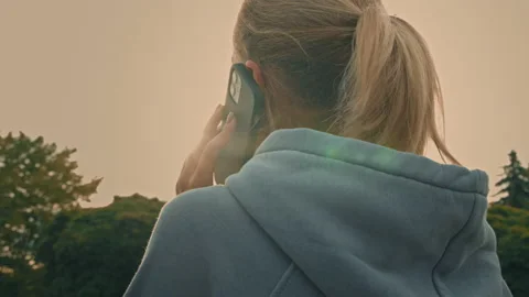 Back view from behind blonde woman sporty young woman answering mobile call Vídeos de archivo 212141153