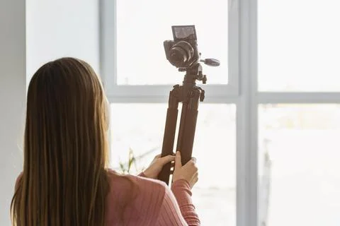 Back view blogger holding tripod up with camera Stock Photos