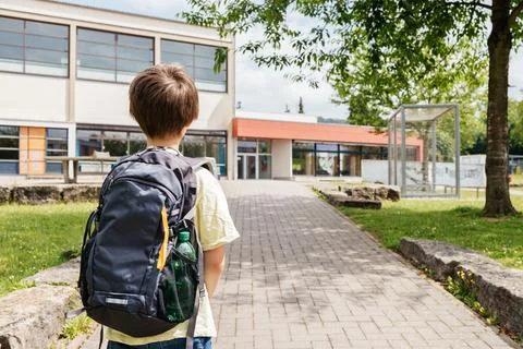 Back view of a boy with a backpack on his back going to school. Back to school Stock Photos