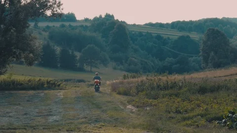 Back view of a boy riding a scooter in the countryside Stock Footage