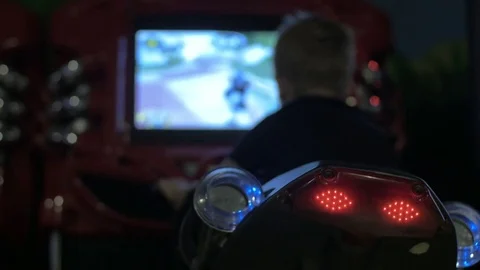 Back view of boy riding toy motorcycle in indoors amusement park Stock Footage 72337906