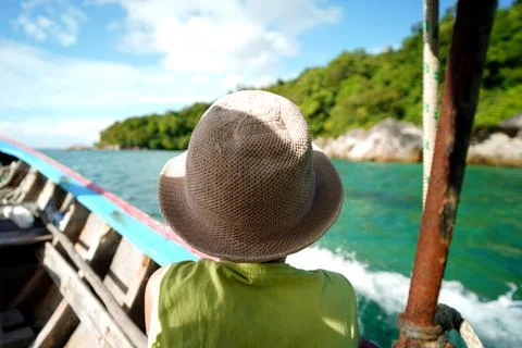Back view of a boy in summer hat sitting in the wooden boat. Travel. Touris.. Foto stock
