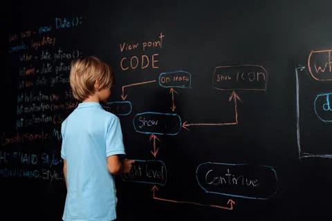 Back view of boy write code on blackboard while stand and thinking. Erudition. Stock Photos