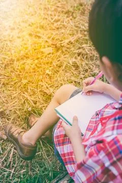 Back view. Boy writing on book. Education concept. Vintage style. Foto stock