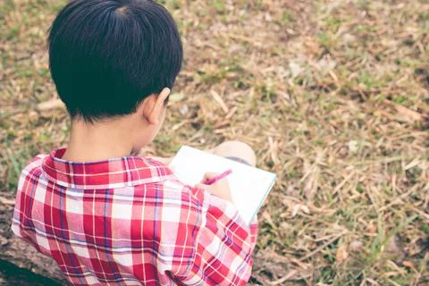 Back view. Boy writing on notebook. Education concept. Vintage style. Stock-Fotos