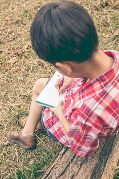 Back view. Boy writing on notebook. Education concept. Vintage style. Stock Photos