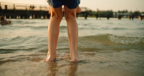 Back view of the boy's legs are jumping through the waves Stock Footage 118366313