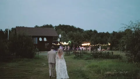 Back view of bride and groom walk to the wedding party. Bride in boho style Vidéo 227881677