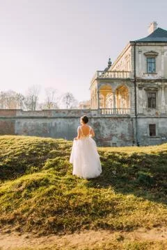 The back view of the bride with nacked shoulder enjoying the architecture of the Stock Photos