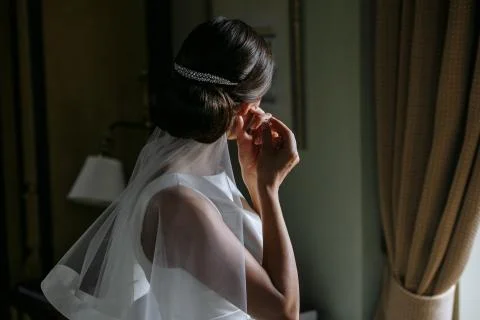 Back view bride puts on earrings Stock Photos