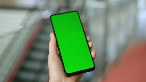 Back view of brunette holding chroma key green screen smartphone watching Stock Footage 155719653