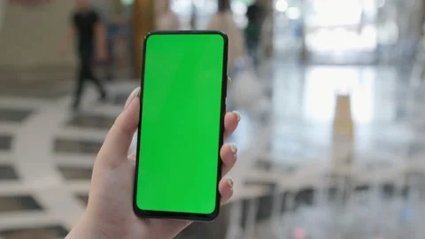 Back view of brunette holding chroma key green screen smartphone watching Stock Footage 209216134