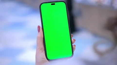 Back view of brunette holding chroma key green screen smartphone watching Stock Footage 267256451