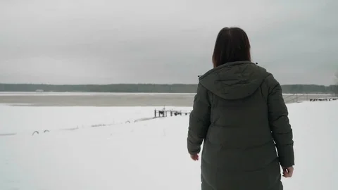 Back view of brunette walking only in coat and sneakers. Winter and everything Video stock 125132884