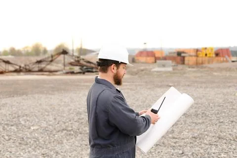 Back view of building engineer standing on construction site, talking by VHF Foto stock
