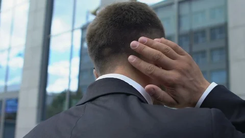 Back view of businessman having neck pain, exhausted after sedentary office work Stock Footage 117223301