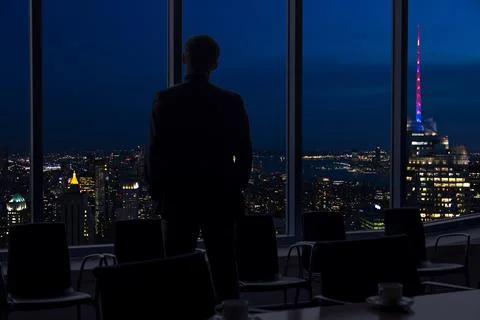 Back view of a businessman looking through window before meeting in New York Stock Photos