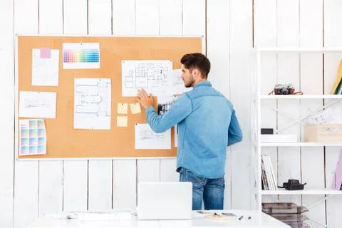 Back view of a businessman posting task stickers on board Stock Photos