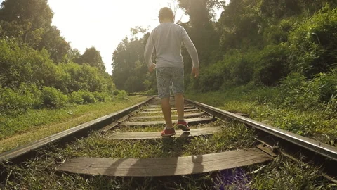 Back view camera movement behind the a Boy walking by railway  Stock-Footage 155334214